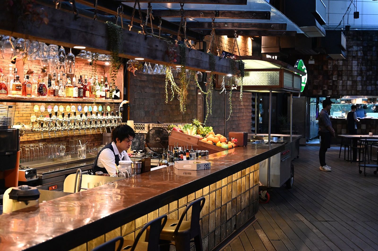 Un bar con poca luz y una barra larga de madera (imagen de muestra)